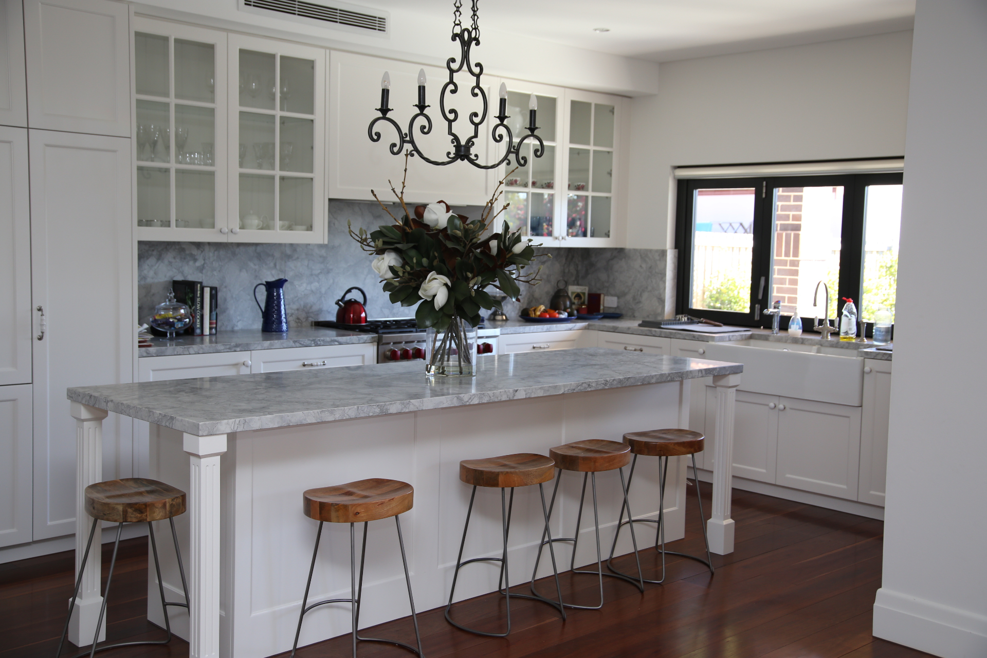 Hamptons-style kitchen with marble benchtops, shaker cabinetry and timber stools built by Mr Woodworx