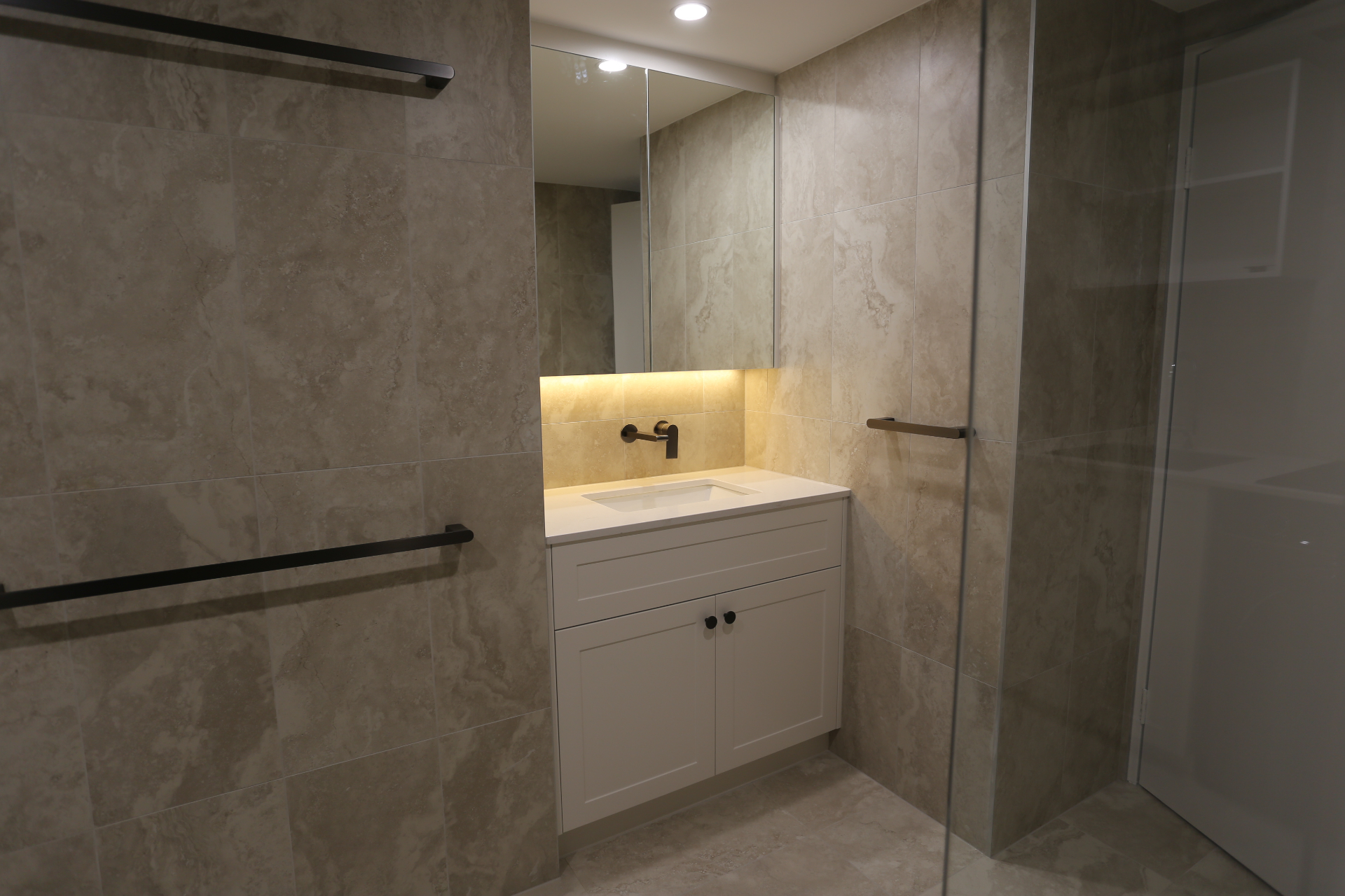 Compact bathroom vanity with mirrored storage and custom cabinetry by Mr Woodworx