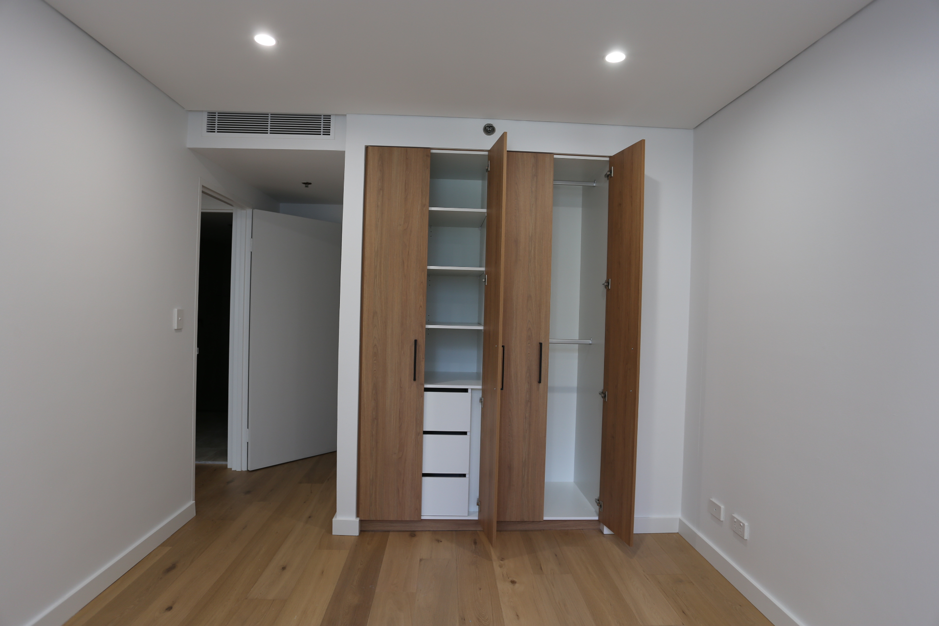 Open built-in wardrobe showing adjustable shelving, drawers and hanging space by Mr Woodworx